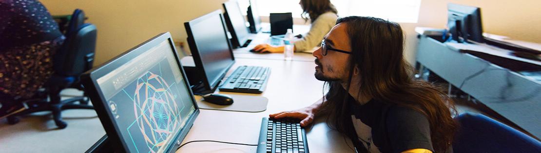 A Pima student sits at a computer with a CAD drawing in a Pima class